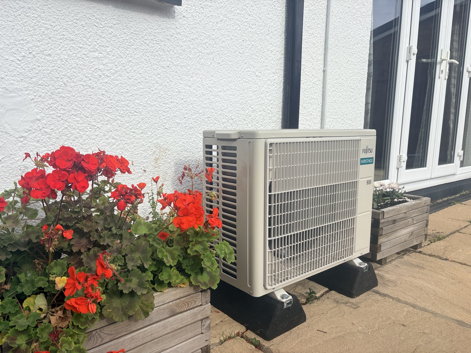 Outdoor unit beside a garden planter